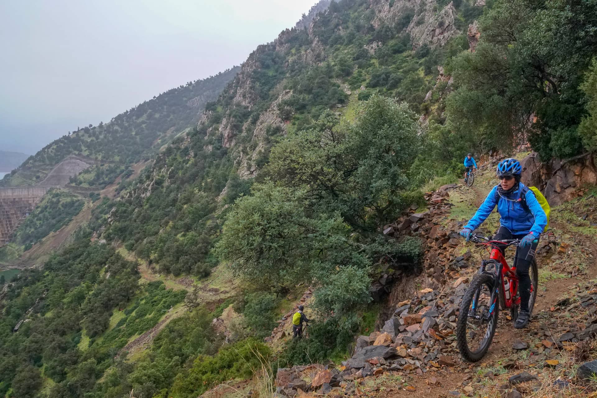 Rider on an e-bike climbing a rocky trail above the Lalla Takerkoust reservoir