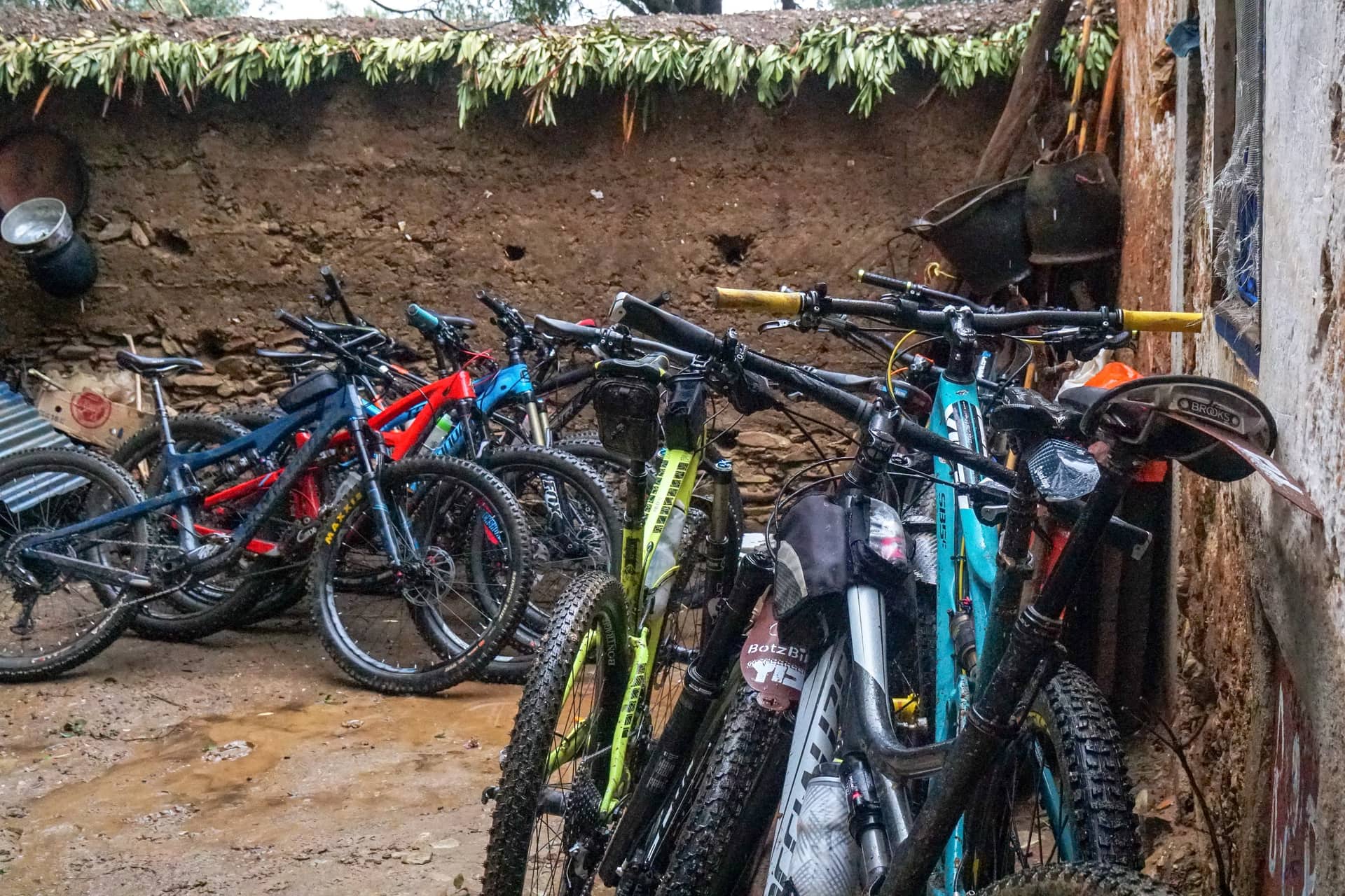 Mountain bikes stored overnight against the rammed-earth wall of a village guesthouse