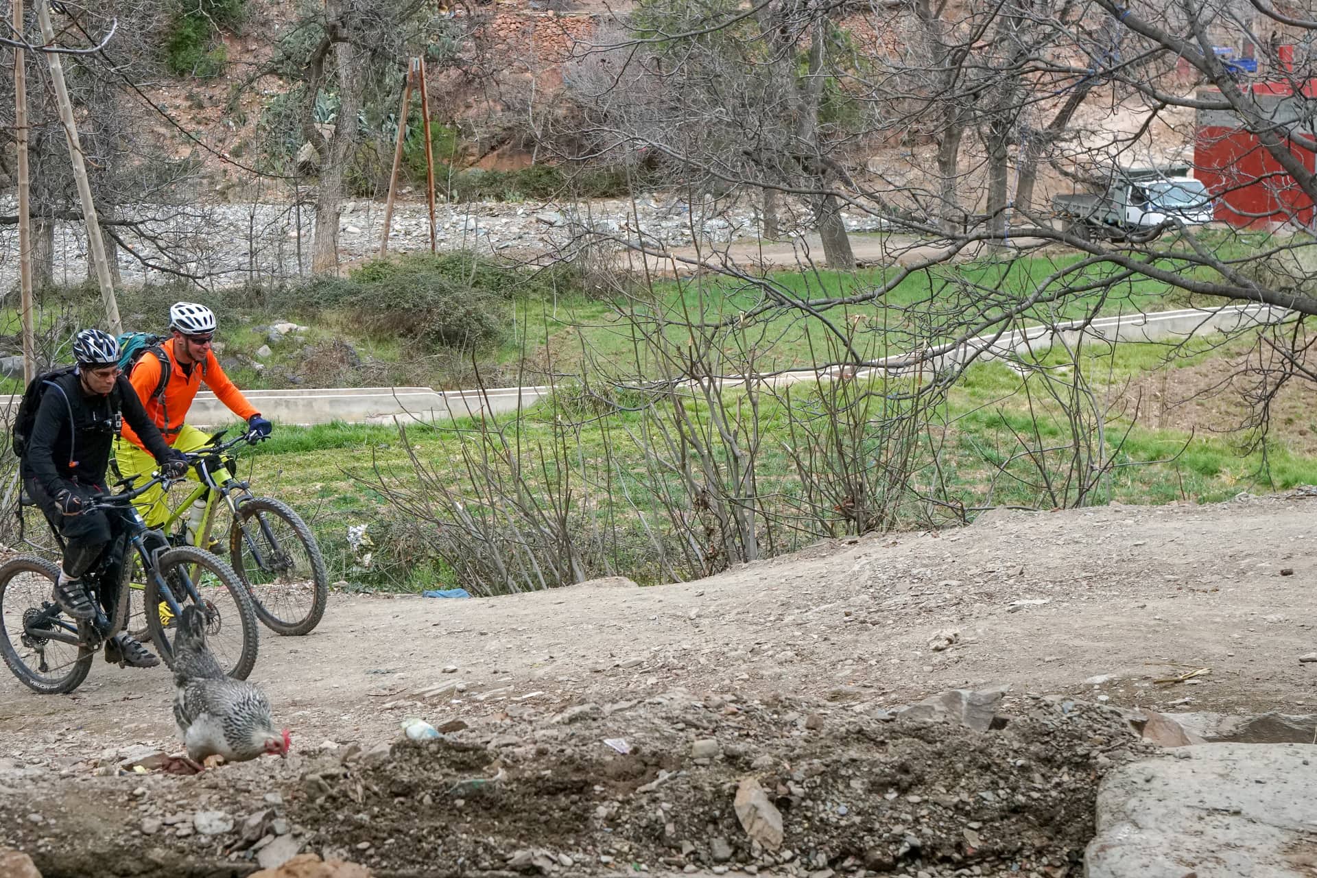 Riders on a piste passing a village mosque