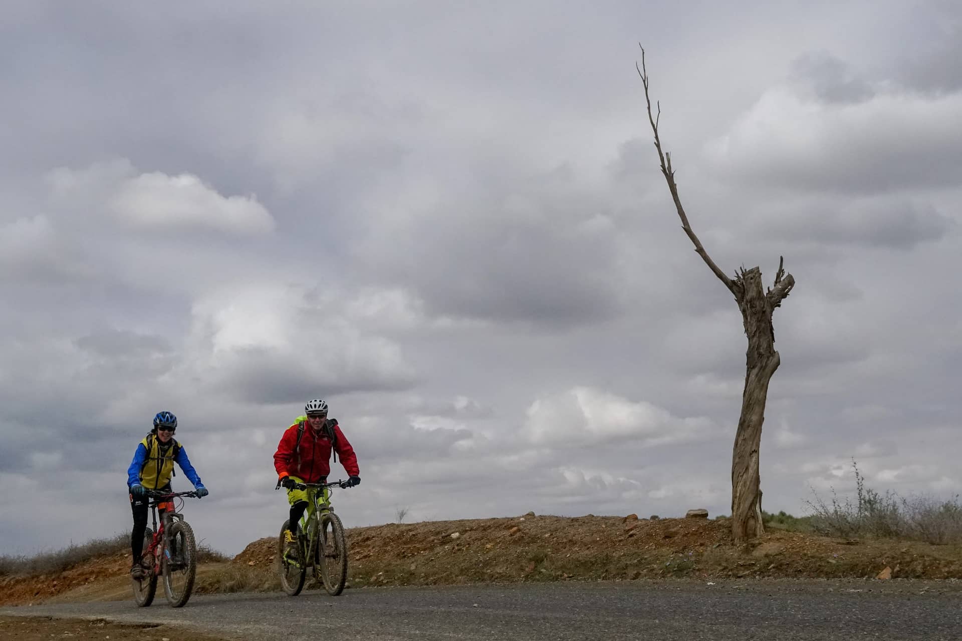Two riders on open ground under a wide sky
