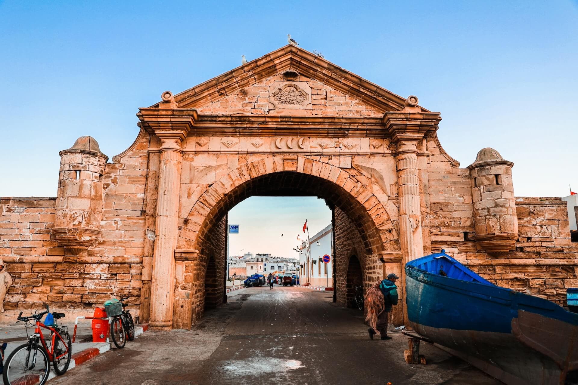 Stone gateway into Essaouira harbour with fishing boats