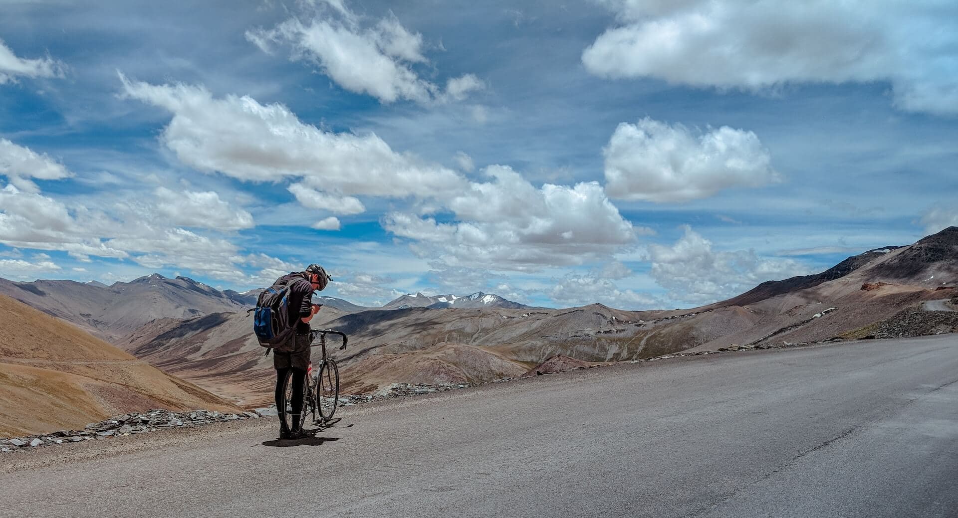 Cyclist resting on a high mountain pass road