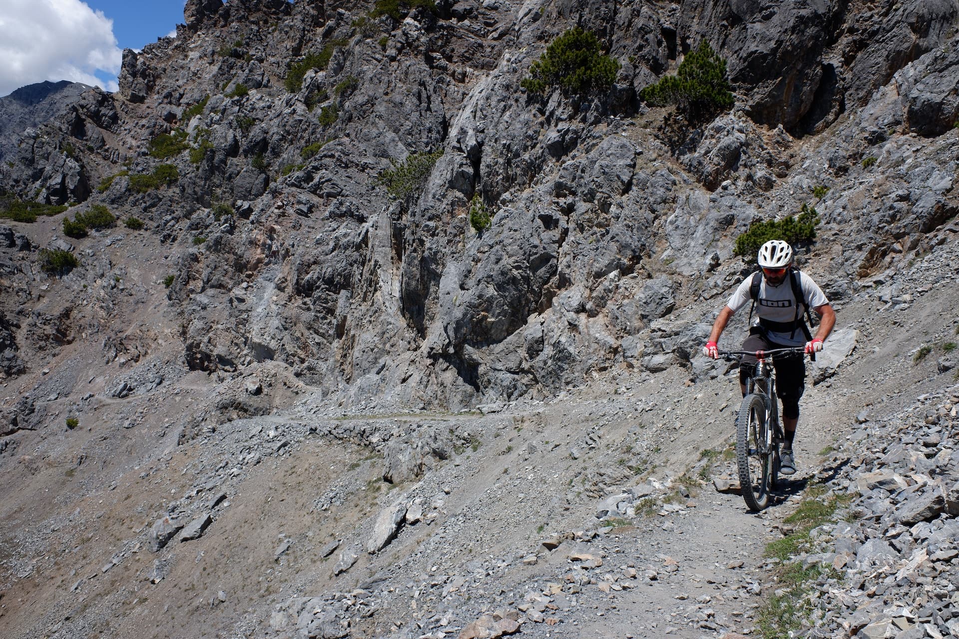 Rider on a track cut through a steep rock gorge in the High Atlas