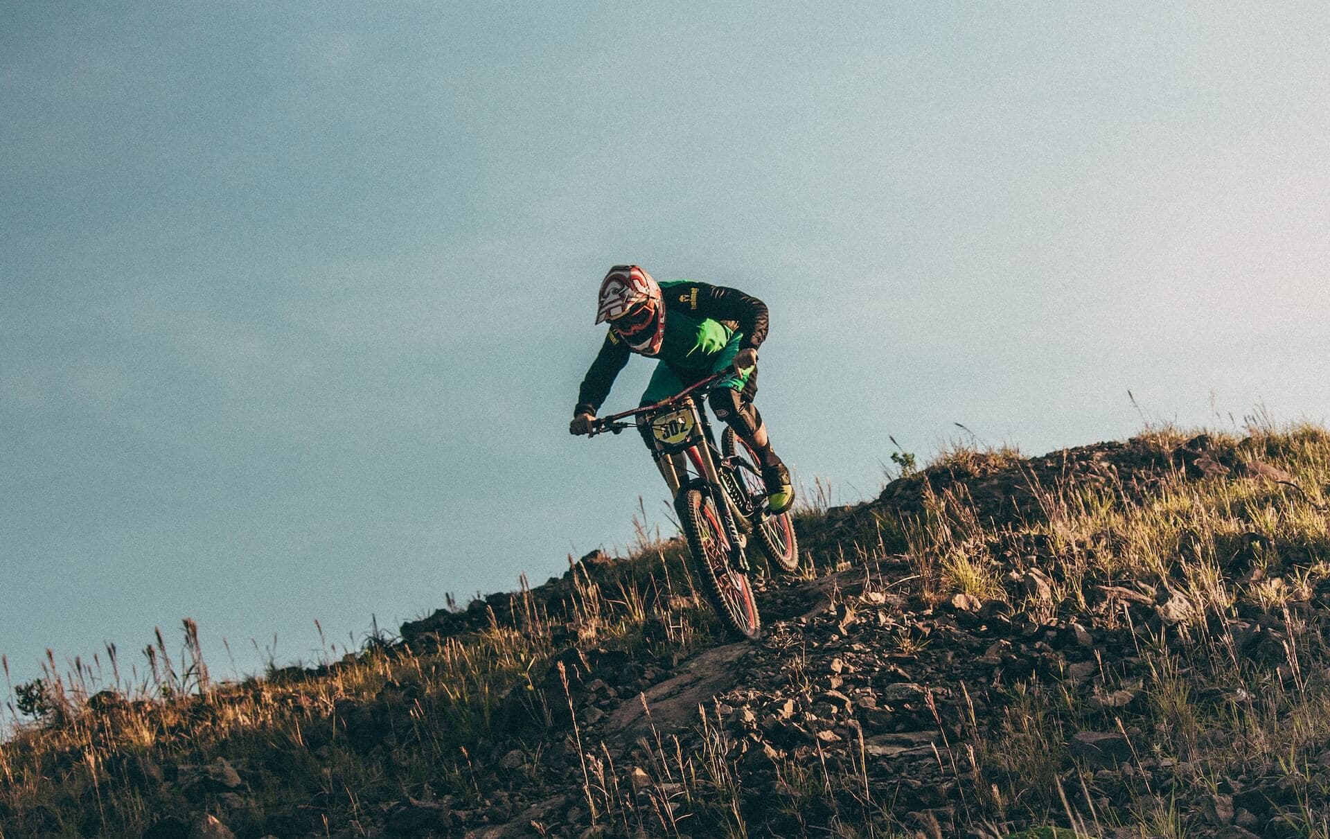 Enduro rider in a full-face helmet on a steep rocky Atlas descent